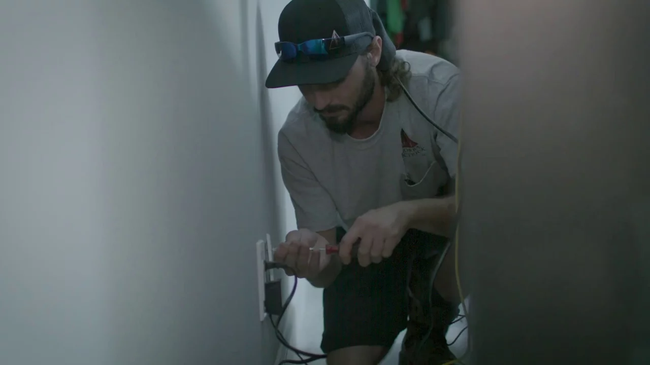 A man fixing an electrical outlet.