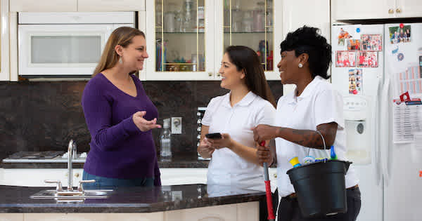 two home cleaners talking with a customer 