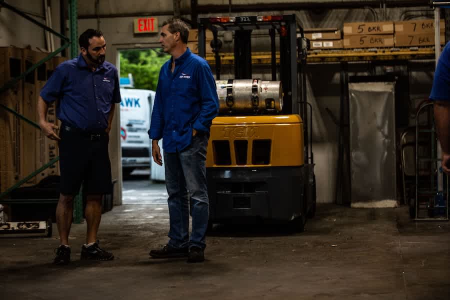 two guys talking in a warehouse