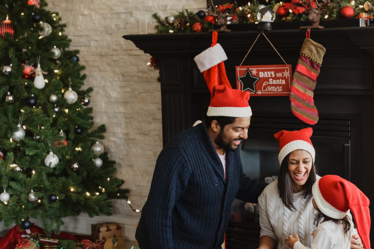 Family laughing together in the living room with Christmas decorations