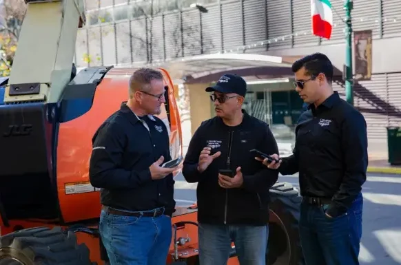 Pros meeting in front of orange boom lift