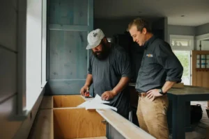 - Housecall Pro Two pros looking at blueprints