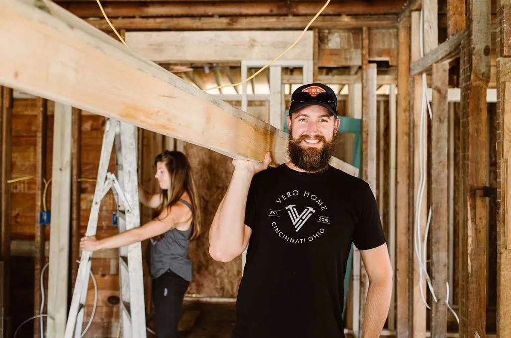 Pro carrying long wooden board over shoulder