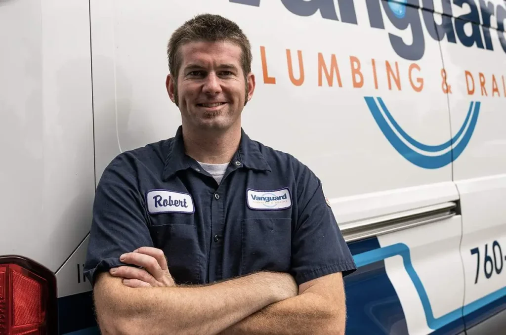 Plumber stands in front of work van