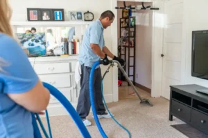 Carpet cleaning pros using vacuum