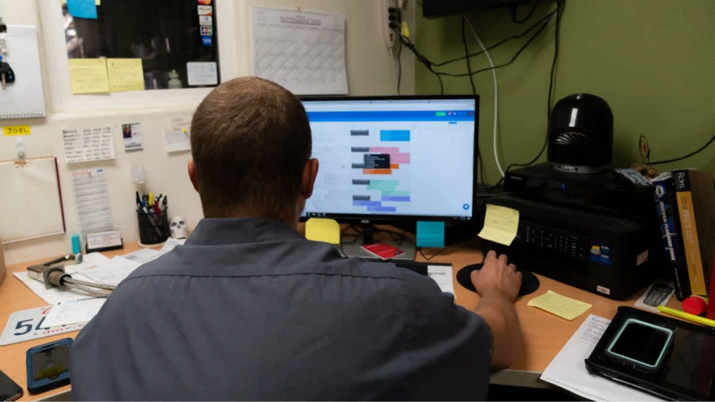 man at computer looking at schedule