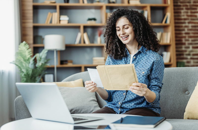 A woman opening a direct mail marketing poscard.