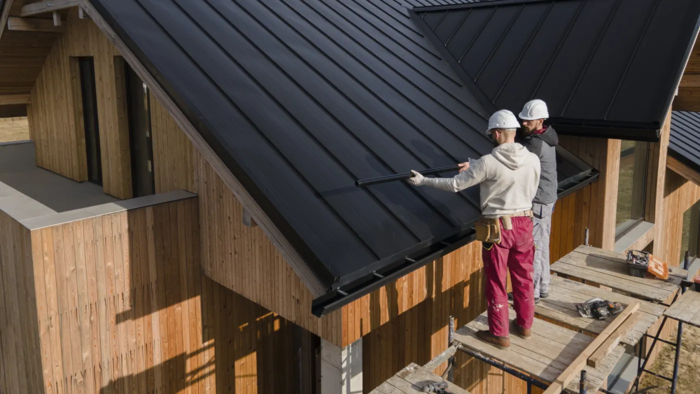 Roofing professionals installing panels on a modern house roof representing average roofer salary insights.