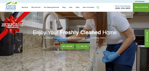 Professional house cleaner wiping a kitchen counter on The Cleaning Authority website homepage.