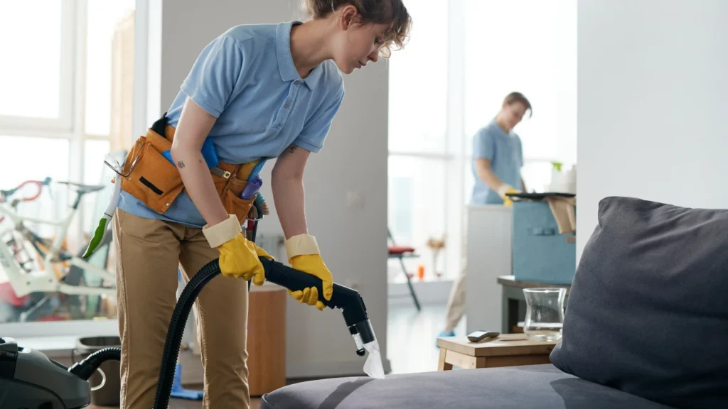 cleaning service workers working in apartment in team, they vacuuming furniture and cleaning the room