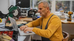 pro is working on a laptop in a workshop