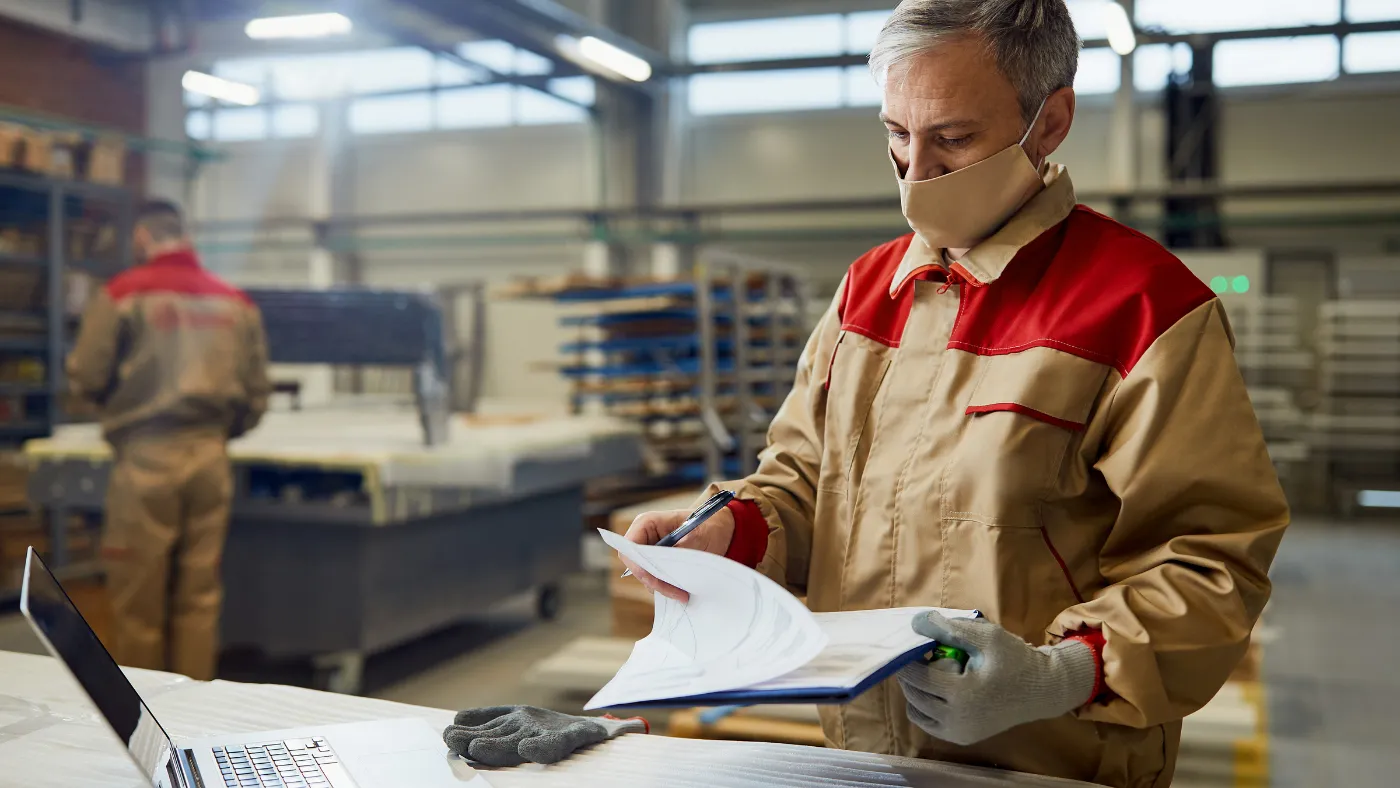 carpentry pro going through paperwork in workshop