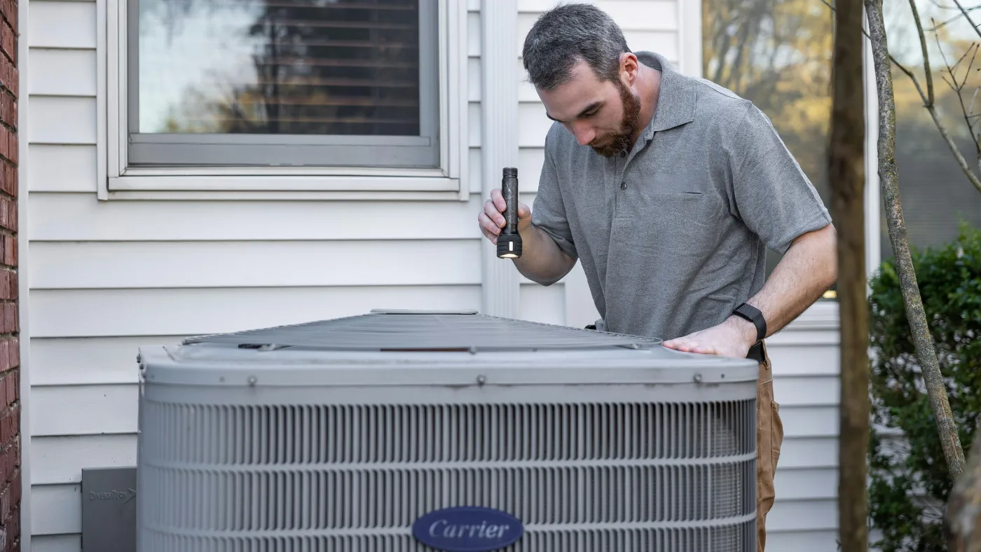 pro HVAC technician inspecting outdoor HVAC unit