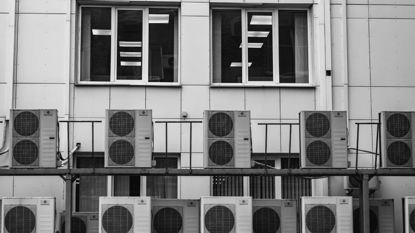 Multiple exterior HVAC condenser units mounted on commercial building wall
