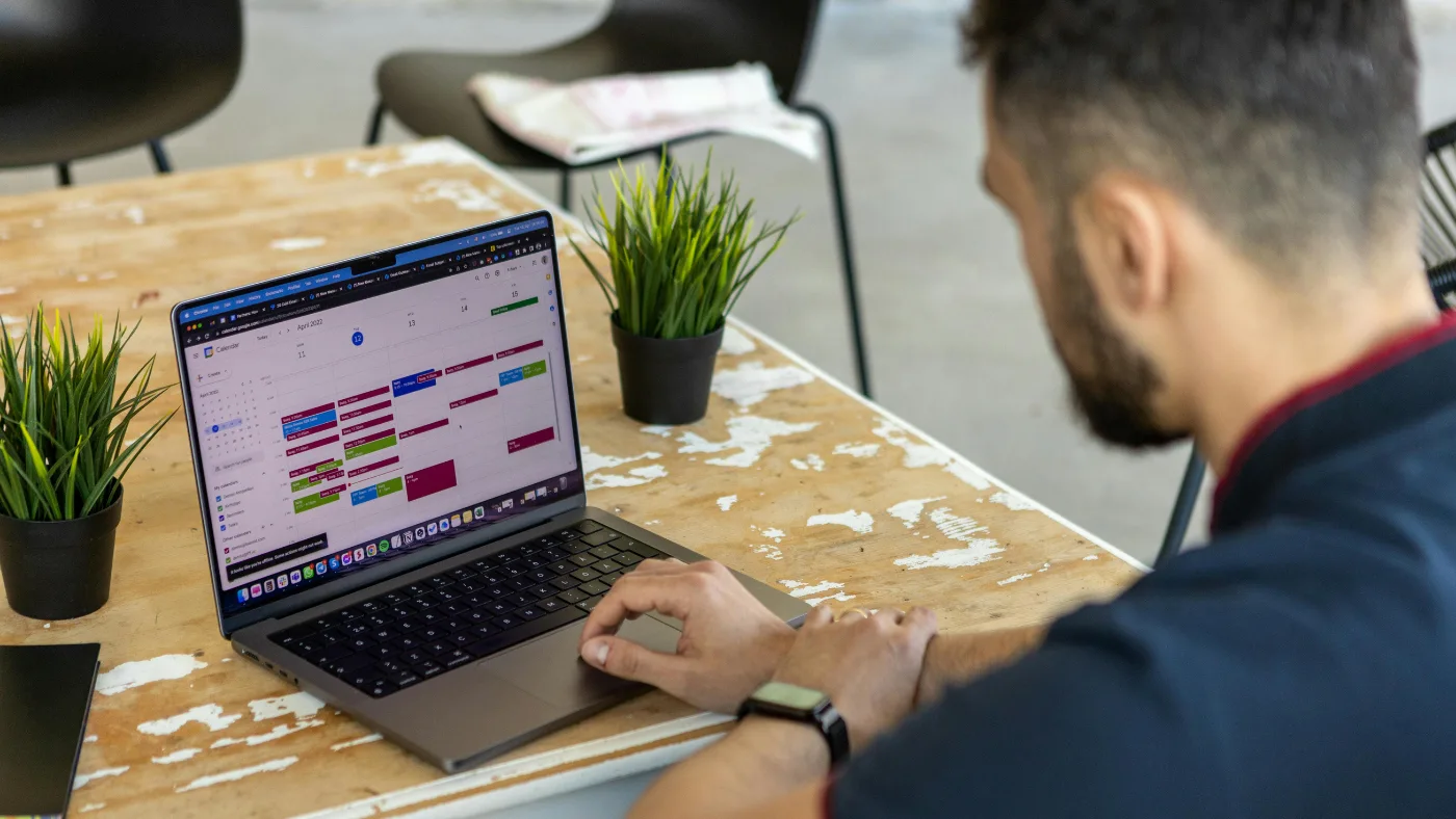 man using google calendar on a laptop