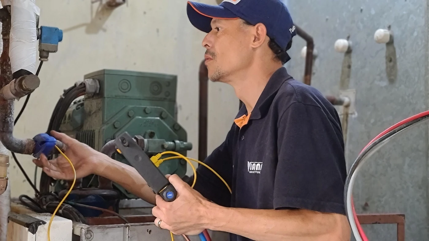 HVAC technician inspecting refrigeration system during equipment maintenance