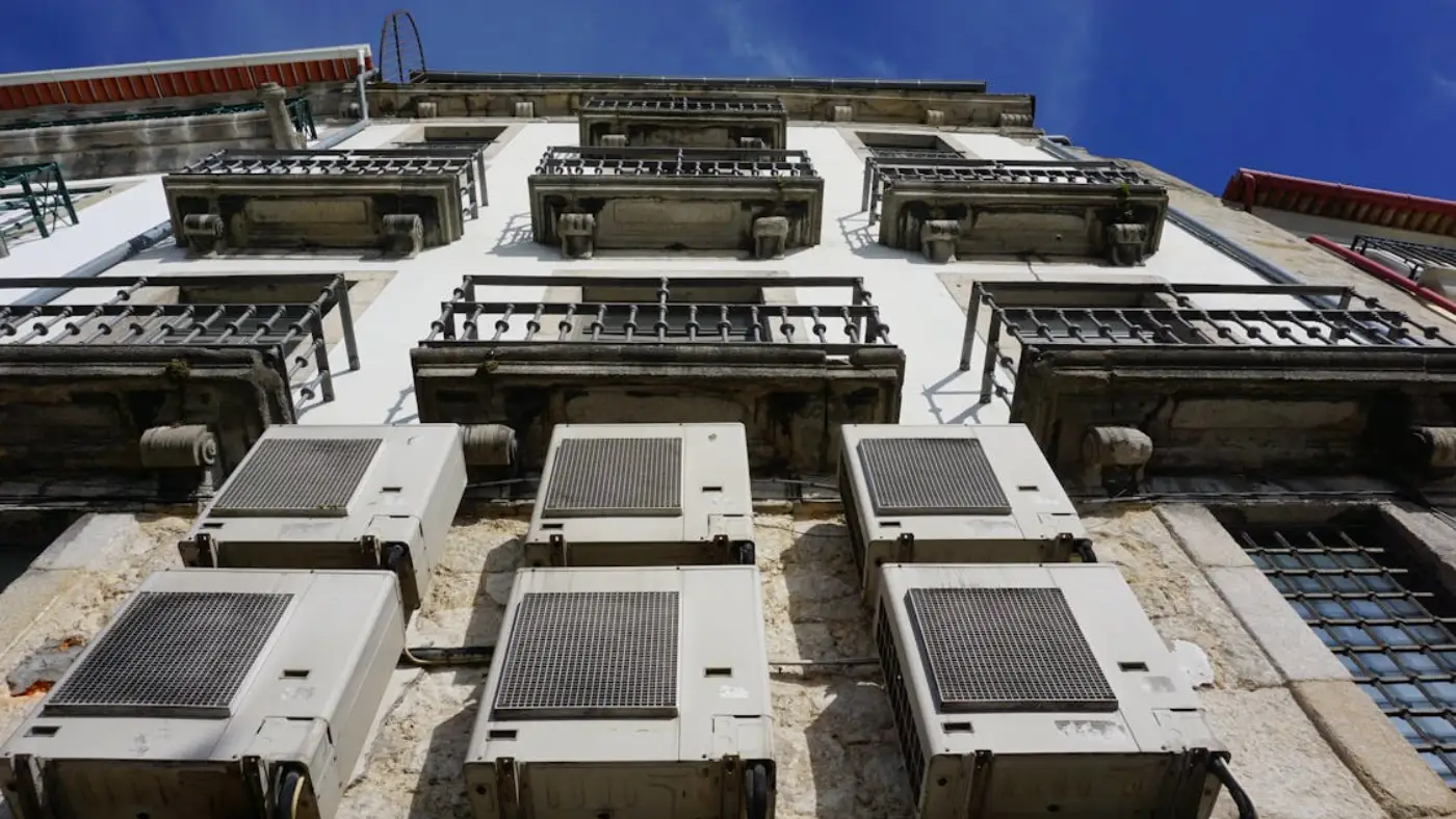Exterior HVAC condenser units mounted on multi-story commercial building façade