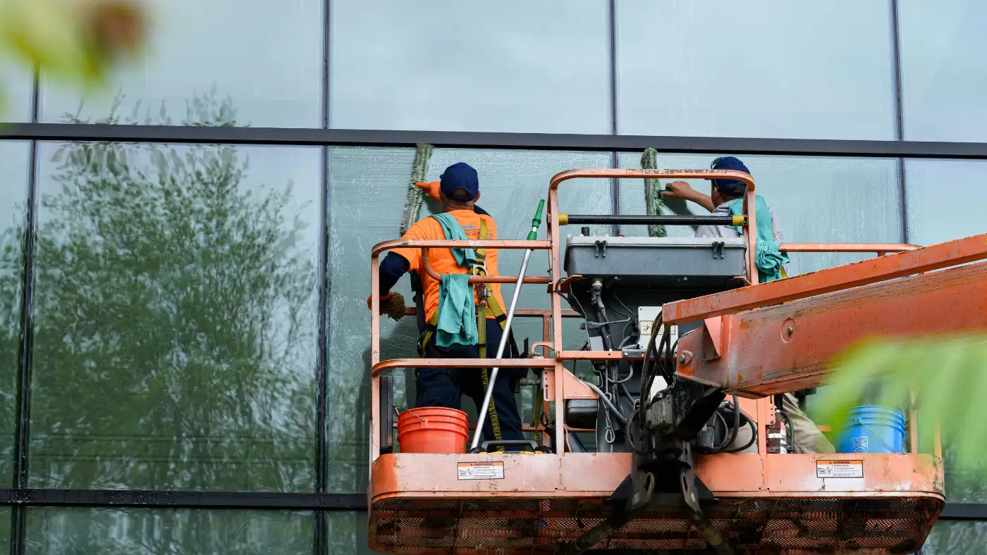 Professional window cleaners working on a glass building