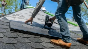Roofing contractor installing asphalt shingles on a residential roof