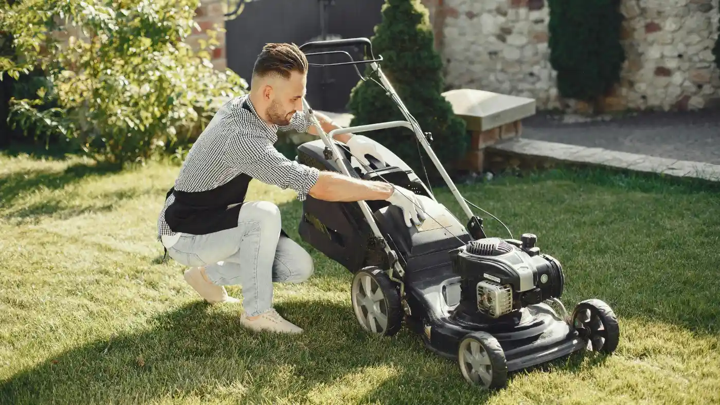 pro holding a black lawn mower