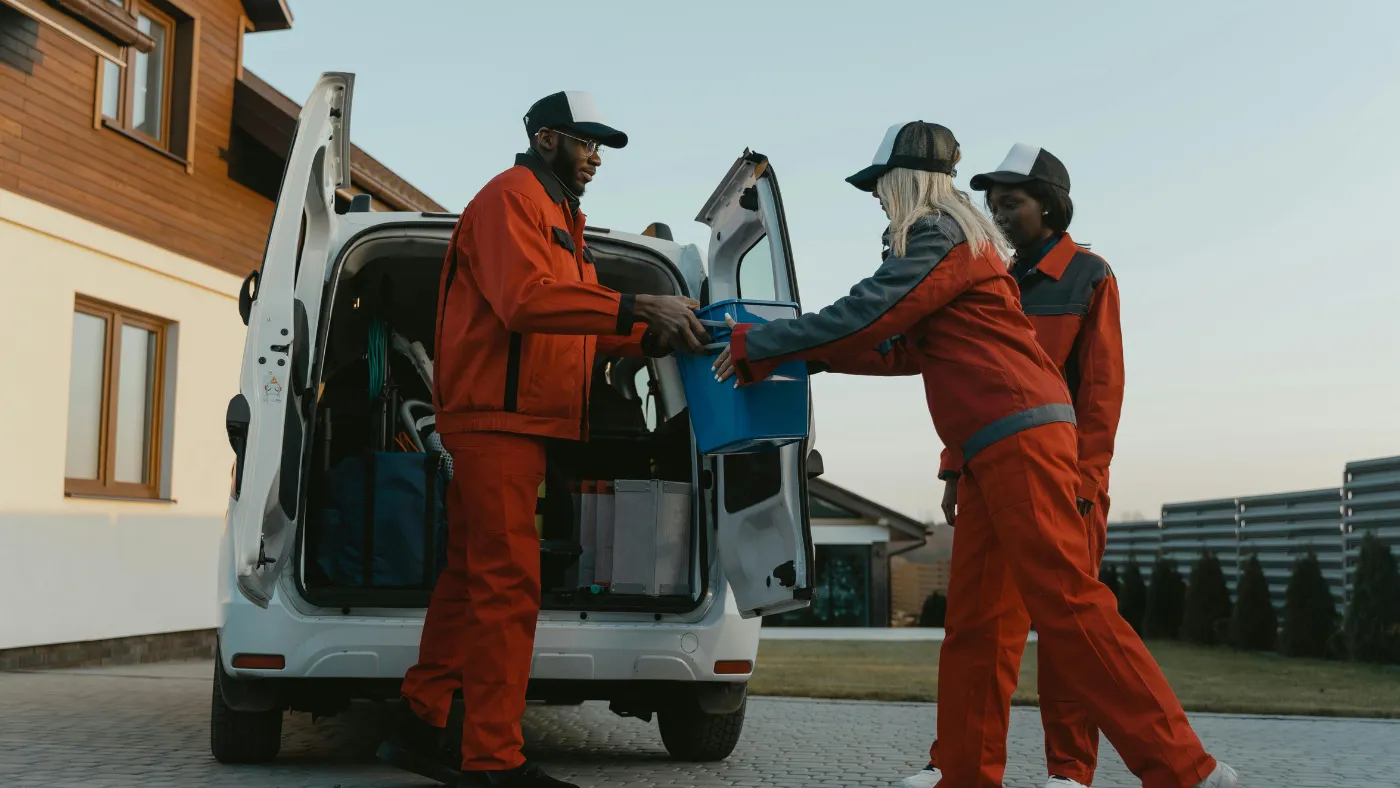 Field service team unloading cleaning supplies from a work van