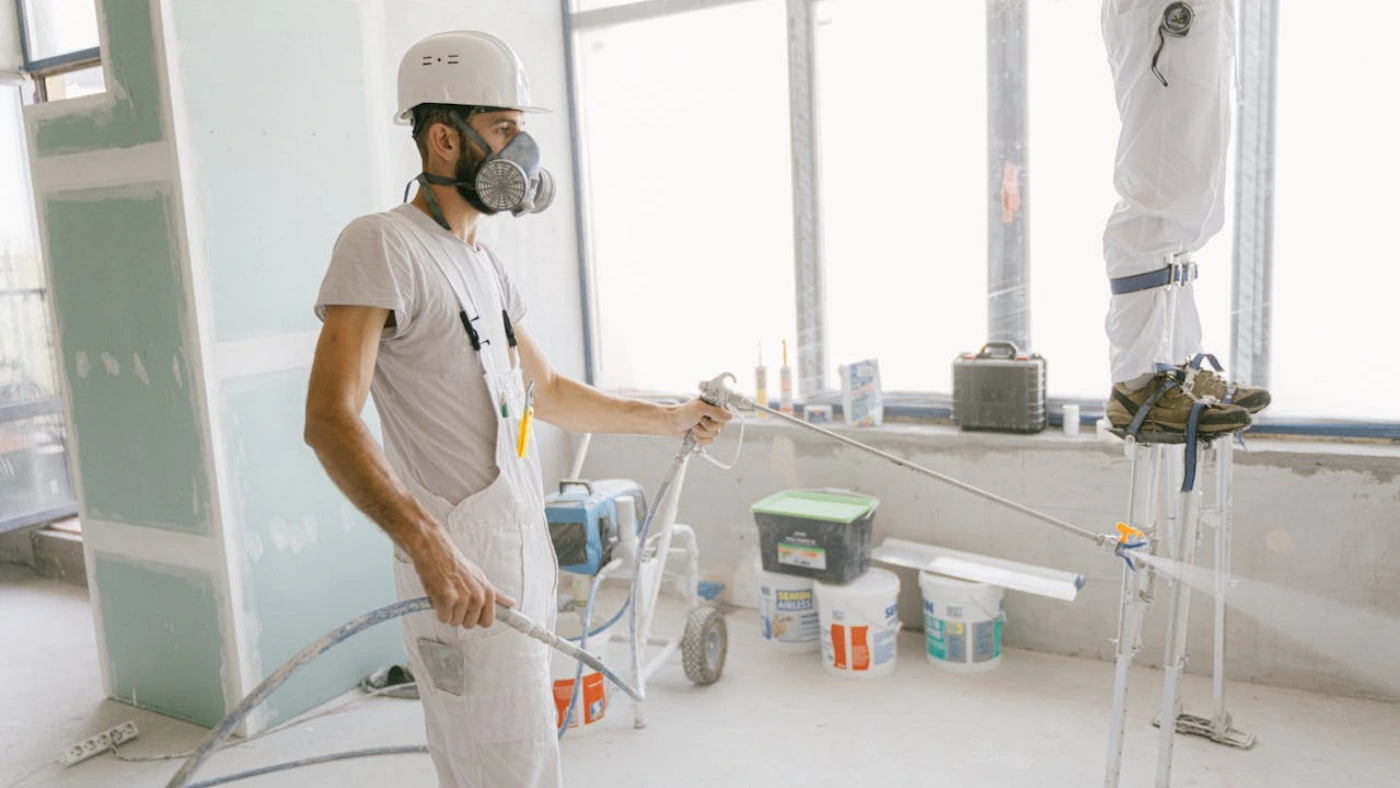 Pro painter using a hose to paint the wall