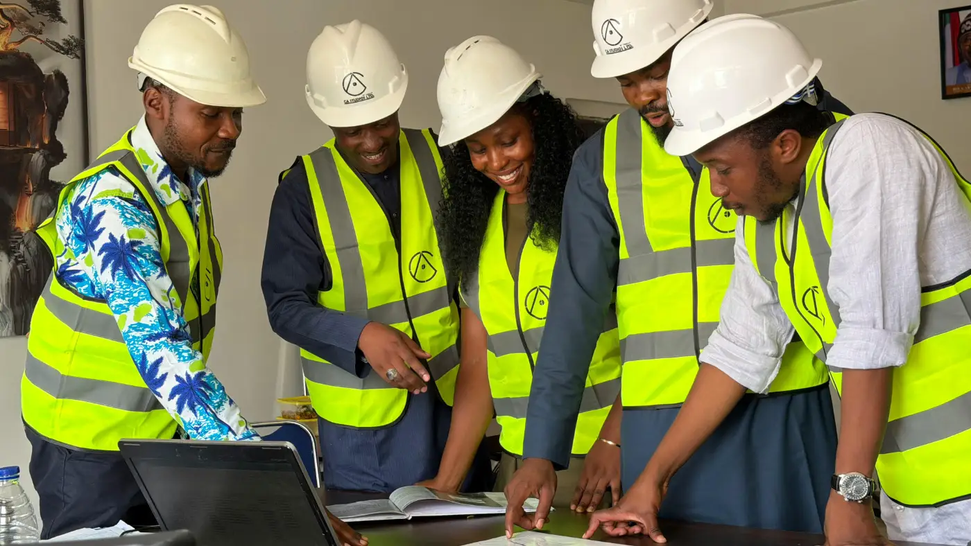 HVAC technicians' team in safety vests reviewing plans during a project meeting