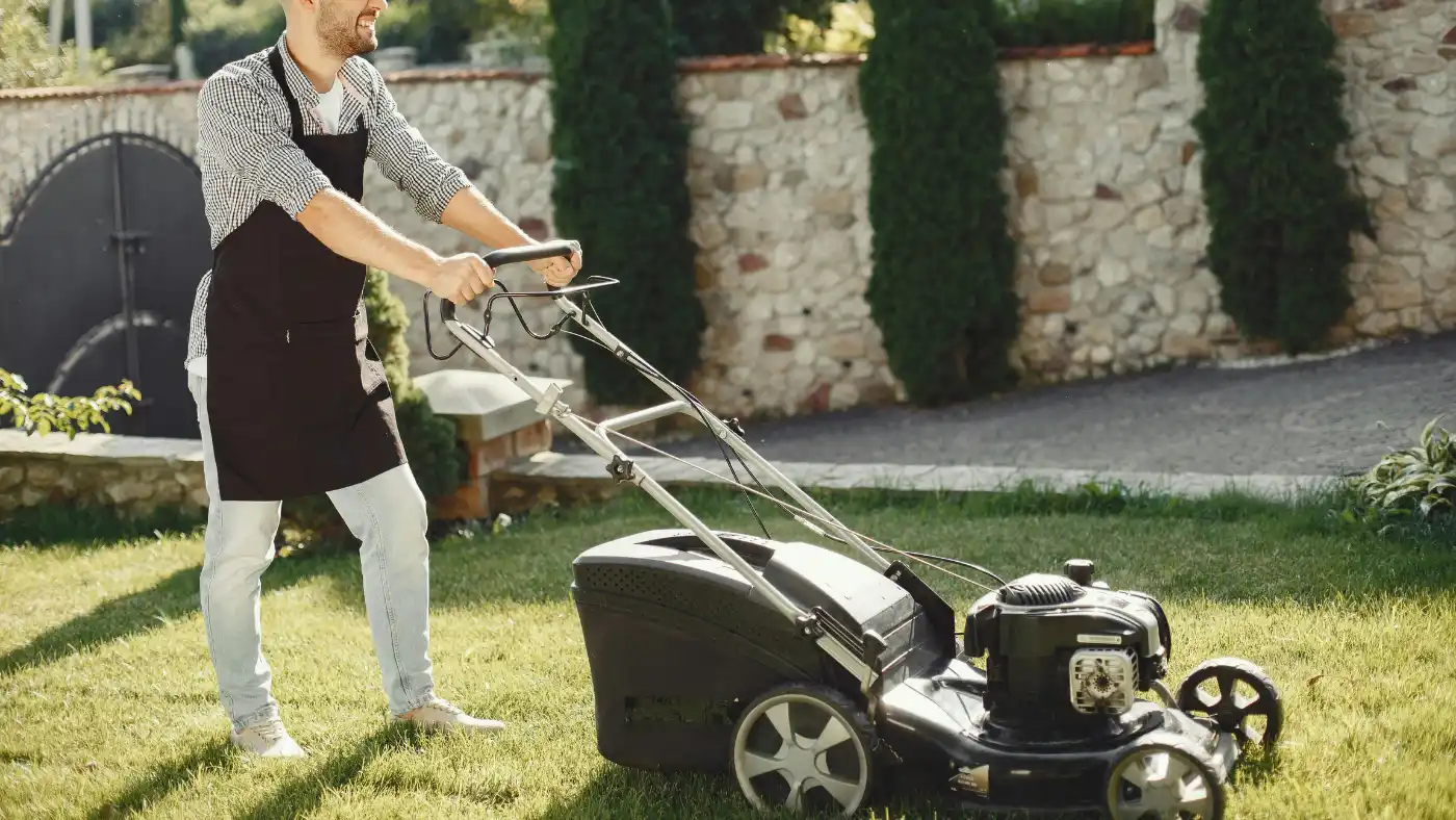 Lawn care professional mowing a residential yard with a push mower
