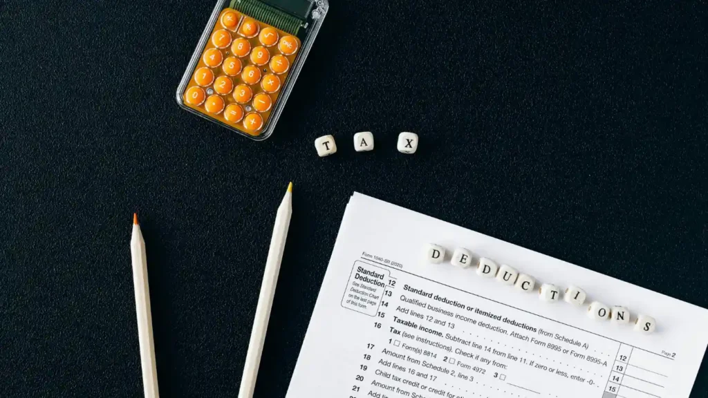 Tax form with calculator and “tax deductions” lettering on desk