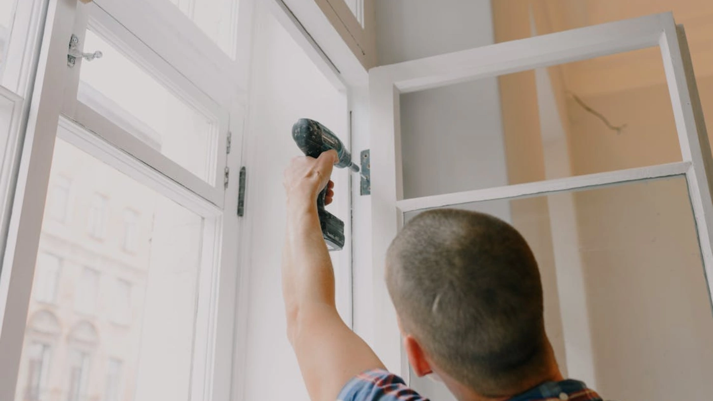 Handyman installing door hinge with power drill for home repair service branding