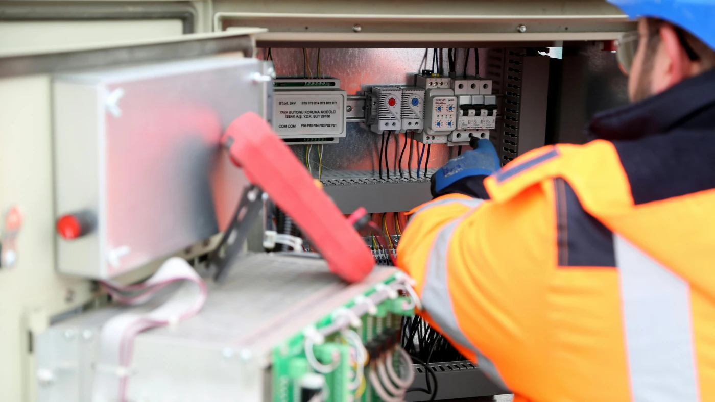 pro electrician inspecting electrical circuit board
