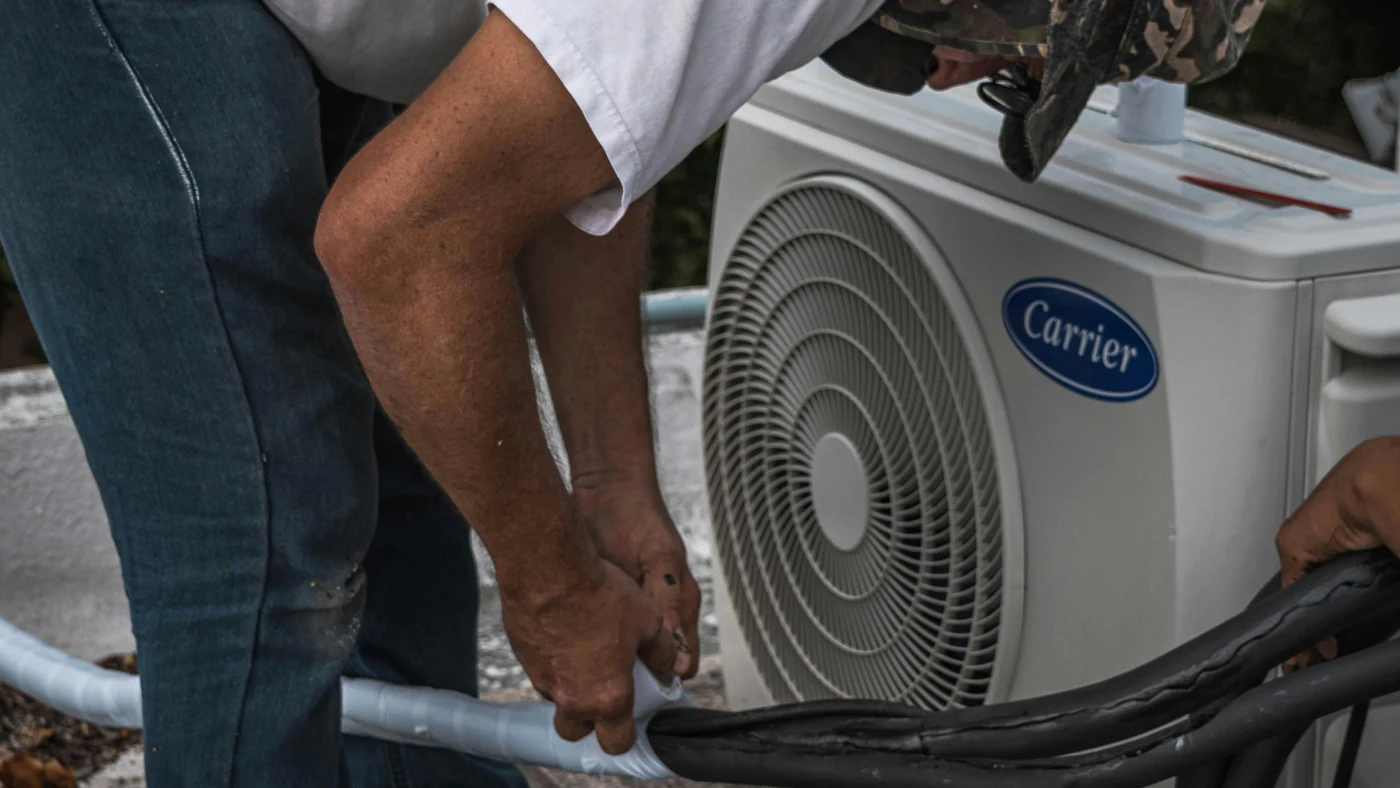 Professional technician performing maintenance on an outdoor air conditioning unit