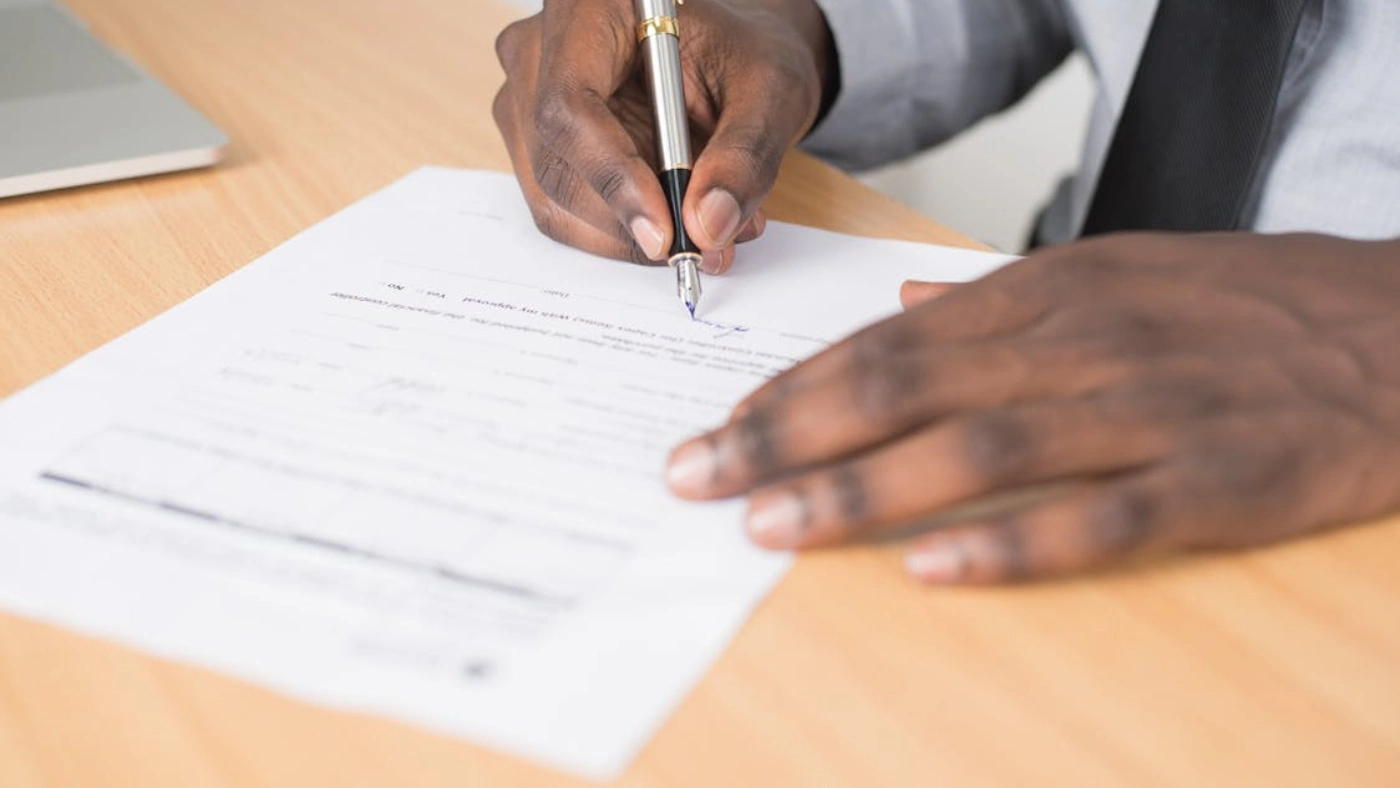 Electrician signing service contract agreement on desk