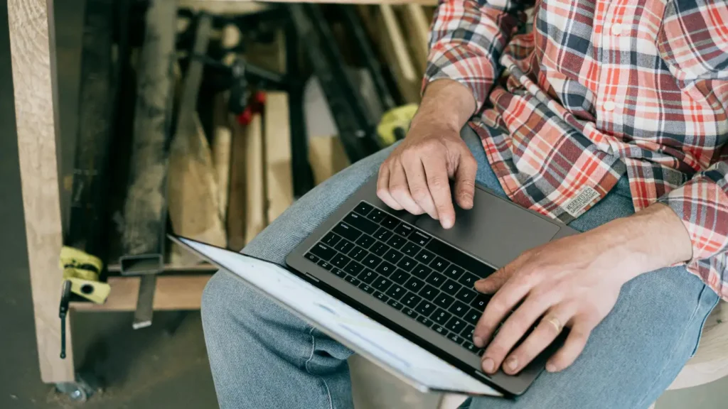 man working on laptop in workshop