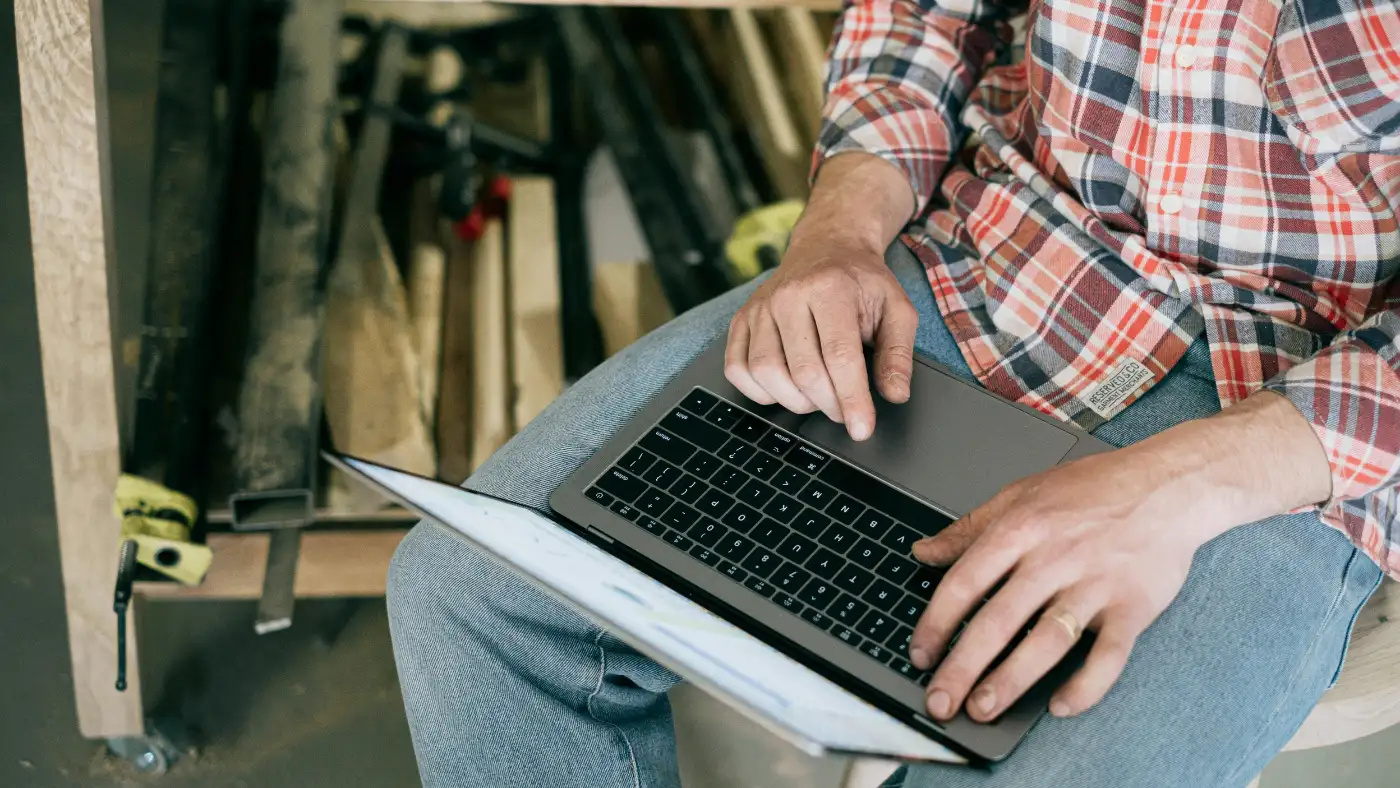 man working on laptop in workshop