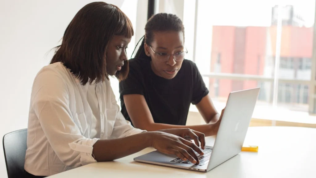 Two professionals reviewing a laptop screen together, representing technical SEO analysis and website optimization