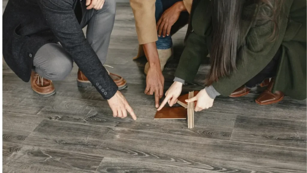 - Housecall Pro People comparing flooring material samples.