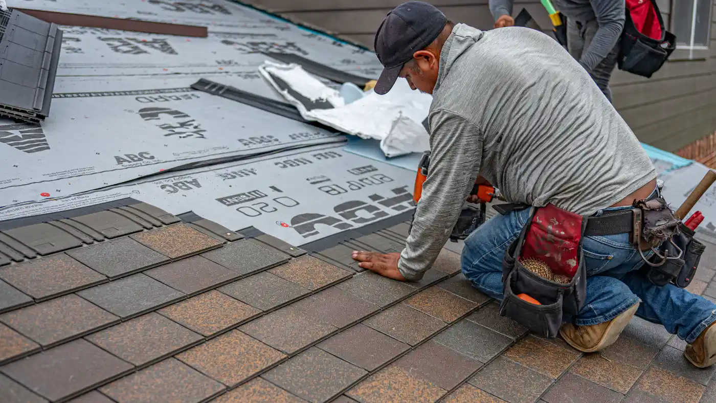 Pro roofer installing shingles and using the roofing nailer