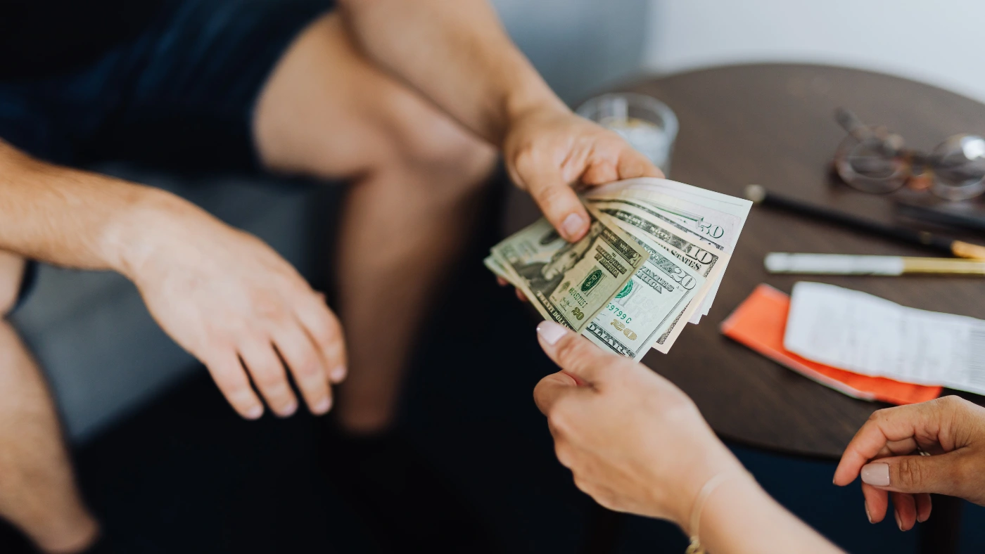 Customer paying an electrician in cash after completing an electrical job.